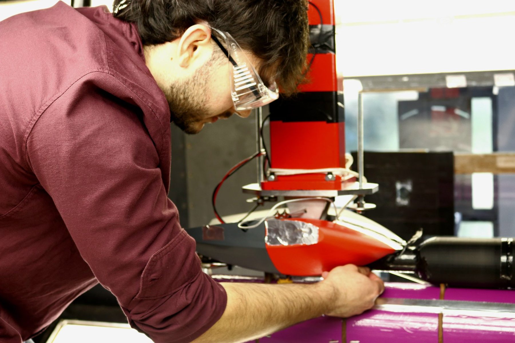 Juan fitting the red printed fairing to the fuselage of the aircraft mounted in the wind tunnel